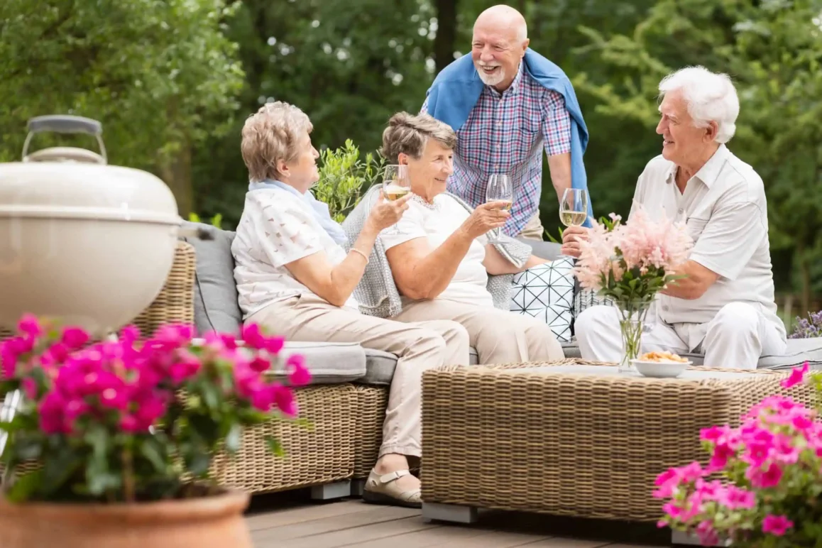 a group of seniors enjoyin a social gatherig outdoors at a luxury assisted living facility in scottsdale
