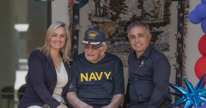 Veteran Celebration at Torbrook Assisted Living in Scottsdale AZ Senior resident wearing a Navy shirt celebrating with staff during a patriotic event at Torbrook Assisted Living in Scottsdale, Arizona, with American flags and decorations