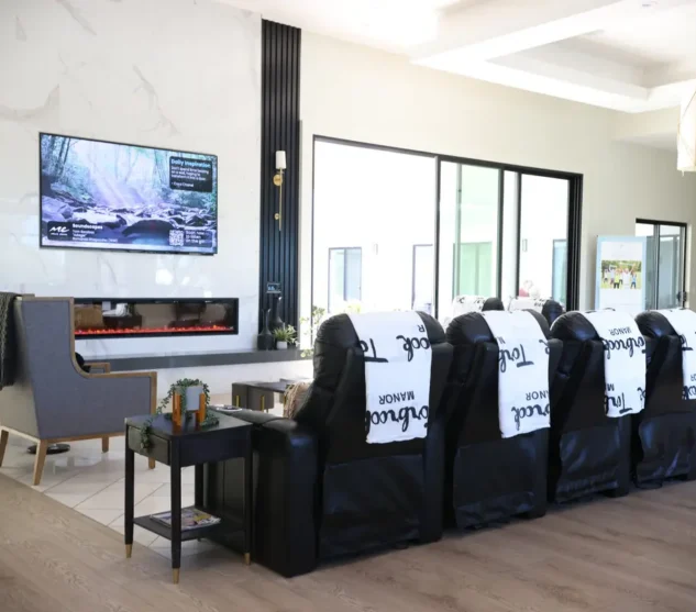 Torbrook assisted living lounge with recliners, a modern fireplace, and TV entertainment for seniors.